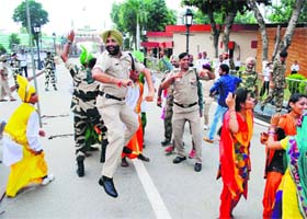 In sync: BSF and police jawans besides children perform dance during the Raksha Bandhan festival at the Wagah border post on Wednesday
