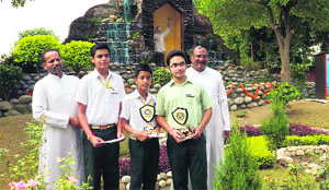Principal of St. Xaviers School Father Eulalio Fernandes (left) with the students and another staff member near the grotto on the school campus. 