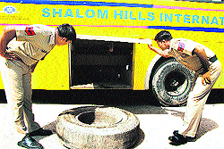 Policemen inspect the tool compartment of the bus where the body of a woman was found in Gurgaon on Wednesday