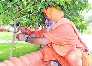 Environmentalist Balbir Singh Seechewal ties a rakhi to a tree on the occasion of Rakshabandhan at Sultanpur Lodhi in Kapurthala district on Wednesday.