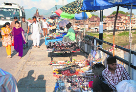 People walk along a footpath full of encroachments in Srinagar. 