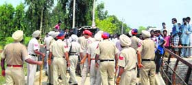 Policemen chase away villagers at Sayeedwala village in Abohar on Wednesday
