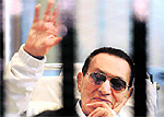 Former Egyptian President Hosni Mubarak waves to his supporters from behind bars in this file photo
