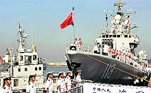 Chinese navy sailors stand on the guided-missile destroyer, Qingdao, before departure for a naval drill at a military port in Qingdao in east China's Shandong province