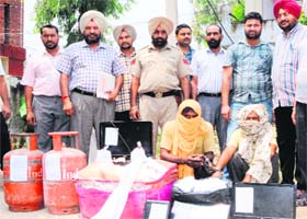Police officials with two arrested robbers and stolen goods in Amritsar on Thursday