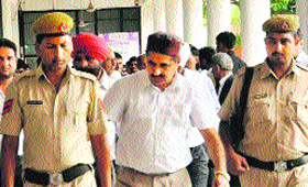 Accused Doon MLA Ram Kumar Chaudhary (centre) being taken to the district courts in Panchkula.