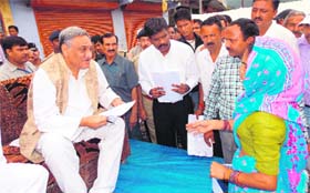 Chief Minister Vijay Bahuguna listens to the problems of the disaster-affected people at Tharali in the Pinder valley of Chamoli on Thursday