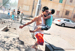Civilians and children are the main victims in the escalating Syrian conflict. This picture shows a man carrying a boy as he runs with other civilians to take cover after what activists said was a missile strike by Syrian Air Force fighter jets loyal to President Bashar al-Assad
