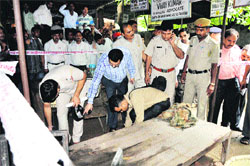 Policemen inspect the Faridabad district courts spot where a man was gunned down on Thursday. 