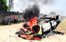 Villagers set a government vehicle on fire during a protest against demolition at Basai village of Gurgaon on Thursday