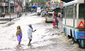 People wade through a waterlogged road in Panipat.