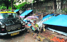 A cancer patient sits on the pavement near a temporary shelter set up outside Tata Memorial Hospital in Mumbai.