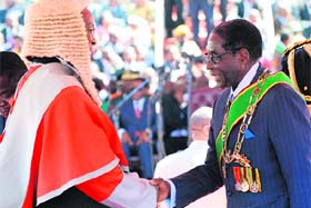 President Robert Mugabe shakes hands with a judge before the swearing in ceremony in Harare on Thursday