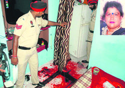 The police investigates the blood-stained floor of the house where Gurjit Kaur (inset) was murdered at Bachint Nagar, near Transport Nagar, in Jalandhar on Friday.