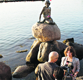 Danish mediapersons in front of Copenhagens landmark Little Mermaid as the statue celebrates her 100th birthday on Friday.