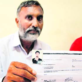 Gurmit Singh shows the picture of his son who was allegedly kidnapped