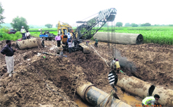 Workers repair the damaged pipeline near Ghuraun village. 