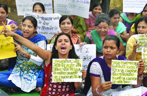 Teachers of the Sarva Shiksha Abhiyan (Education for All Movement) hold placards and shout slogans, demanding fixed salaries during a protest in New Delhi on Saturday. 