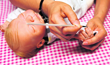 Van Landeghem paints the nails on Loan, one of her "Reborn Baby" dolls.