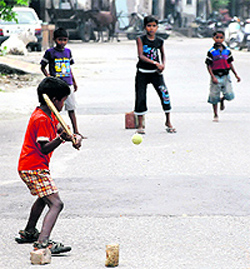 Children play cricket in a street in Bathinda