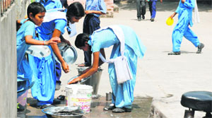 Students wash their plates after a mid-day meal at a government school in Sector 12, Panchkula. 