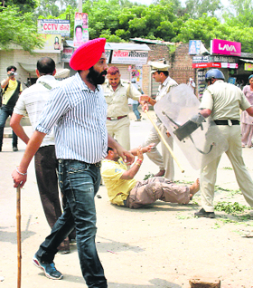 Policemen beat up a protester in Jind on Sunday.