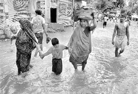 People wade through a flooded street at Vindhyachal Dham in Mirzapur on Sunday.