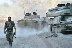 A Syrian army soldier walks on a street in the Jobar neighborhood of Damascus on Saturday. 