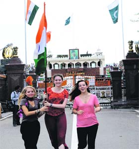 Mera Bharat mahaan: Foreigners hold the Tricolour in their hands during the Retreat Ceremony at the Wagah check post