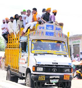 Endangering lives: People travel on the top of an overloaded truck in Amritsar on Monday