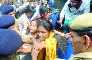 Police personnel detain JNU students during their protest, demanding an increase in 