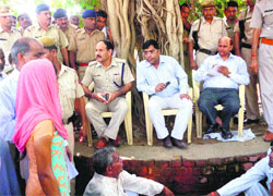 Dr Raj Kumar, a member of the National Commission for Scheduled Castes (centre), talks to the victims relatives in Jind on Monday. 
