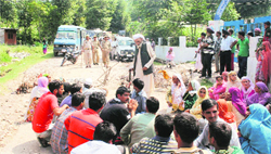 Residents of border villages sit on a dharna on the