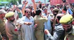 Police personnel detain employees of the Urban Local Bodies Department during a protest in Srinagar on Monday. Tribune Photo: Amin War 