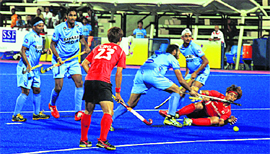 Sardar Singh fights for the ball against Korea on Monday.