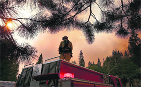 A member of the West Stanislaus Country Fire Department monitors the rim fire in California.