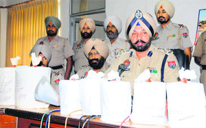 The DIG (Border Range) Paramraj Singh Umranangal and other police officials show 4 kg heroin and 5 kg white powder recovered from two smugglers Ranjit Singh and Amarjit Singh