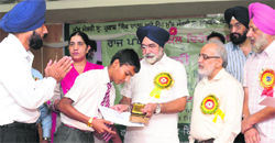 Education Minister Sikander Singh Maluka honours a student who won the poster-making and slogan-writing competition held as part of the anti-copying campaign in Bathinda on Tuesday. Tribune photo: Pawan Sharma
