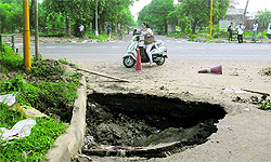 A woman scooterist takes a detour to avoid a damaged road in Mohali on Tuesday