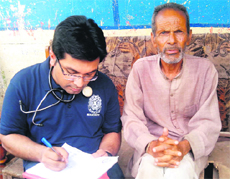 Dhirajmani (right), who lost his speech, is attended by a doctor in Parodi village. 
