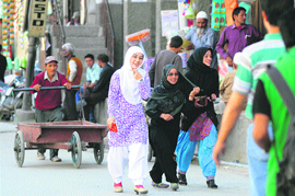 The counting of votes will be held at Degree College, Kargil, on Wednesday and the results are expected by midnight. Here, girls walk through a market in Kargil.