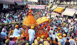 Devotees take part in a procession as part of Janmashtami celebrations in front of Raghunath Temple in Jammu on Tuesday