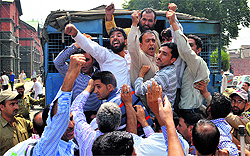 Policemen detain employees of the J&K Urban Local Bodies Department during a protest in Srinagar on Tuesday. The employees were demanding regularisation of contractual jobs and an increase in monthly salary