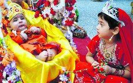 A girl cradles a toddler dressed as Lord Krishna at Kiddies Paradise