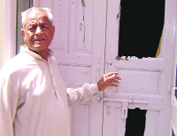 Ricky Dullats father-in-law Prem Chand shows the broken door of his house in Sangrur on Tuesday. A Tribune photo