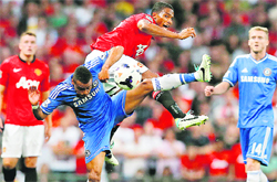 Manchester Uniteds Antonio Valencia challenges Chelseas Ashley Cole during their English Premier League match at Old Trafford on Monday.  Reuters