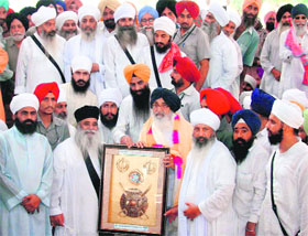 Chief Minister Parkash Singh Badal being presented a memento by Baba Ghala Singh and Baba Lakha Singh at Gurdwara Nanaksar Sahib near Jagraon on Wednesday. 
