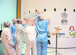 The decal for GSAT-7 is being fixed on the satellite at the spaceport at French Guyana.