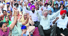 Residents protest outside the GMADA office in Phase VIII, Mohali, on Thursday.