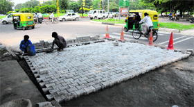 Workers pave tiles at the Sector 29/30/31/32 roundabout.